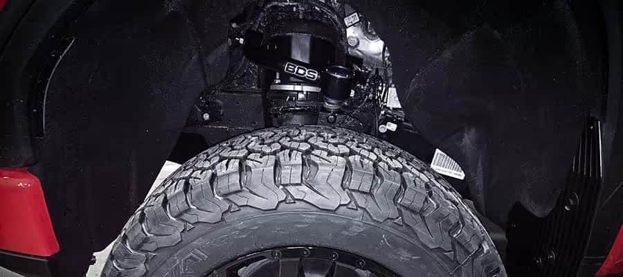 Close-up of a vehicle's wheel well featuring a rugged tire and BDS suspension system.