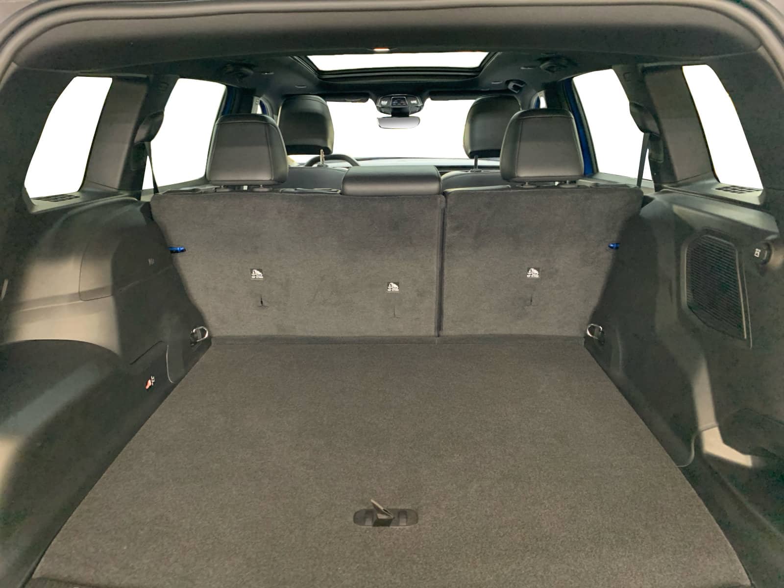 Spacious SUV trunk with folded rear seats, showcasing ample cargo space and interior features.