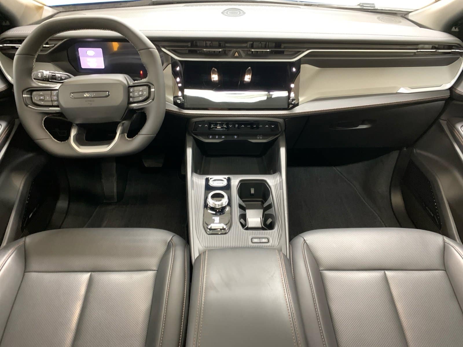 Modern SUV interior with sleek dashboard, digital display, multifunction steering wheel, and center console.