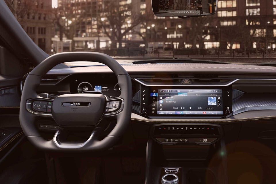 Jeep interior with a sleek steering wheel, digital dashboard, and modern infotainment system.